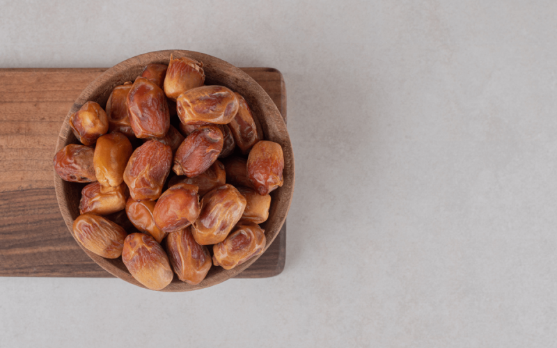 yellow-dry-dates-isolated-wooden-platter